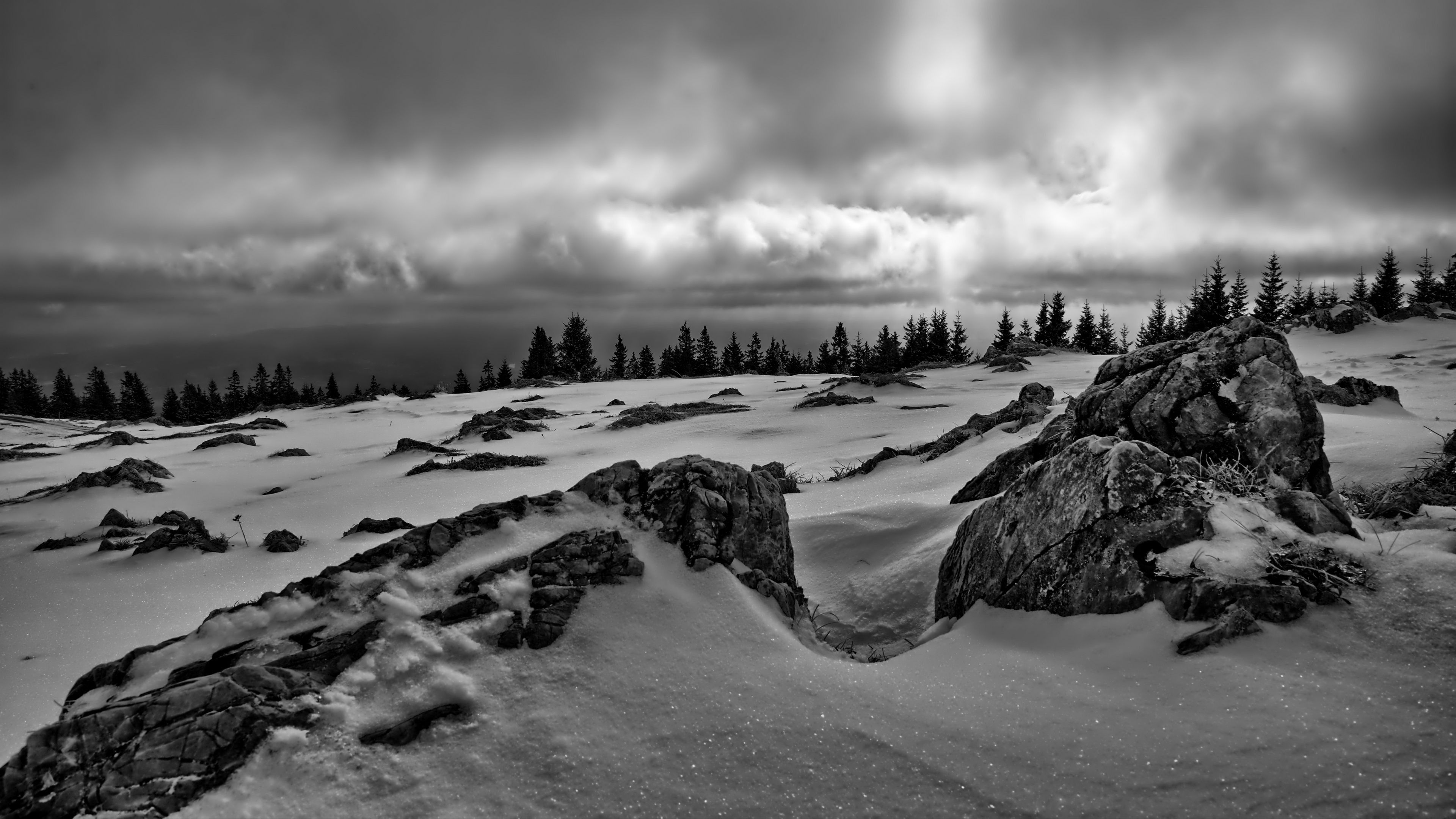 Black And White Image Of Snow Covered Rocks Trees Under Black White Clouds Sky 4K HD Winter Wallpaper