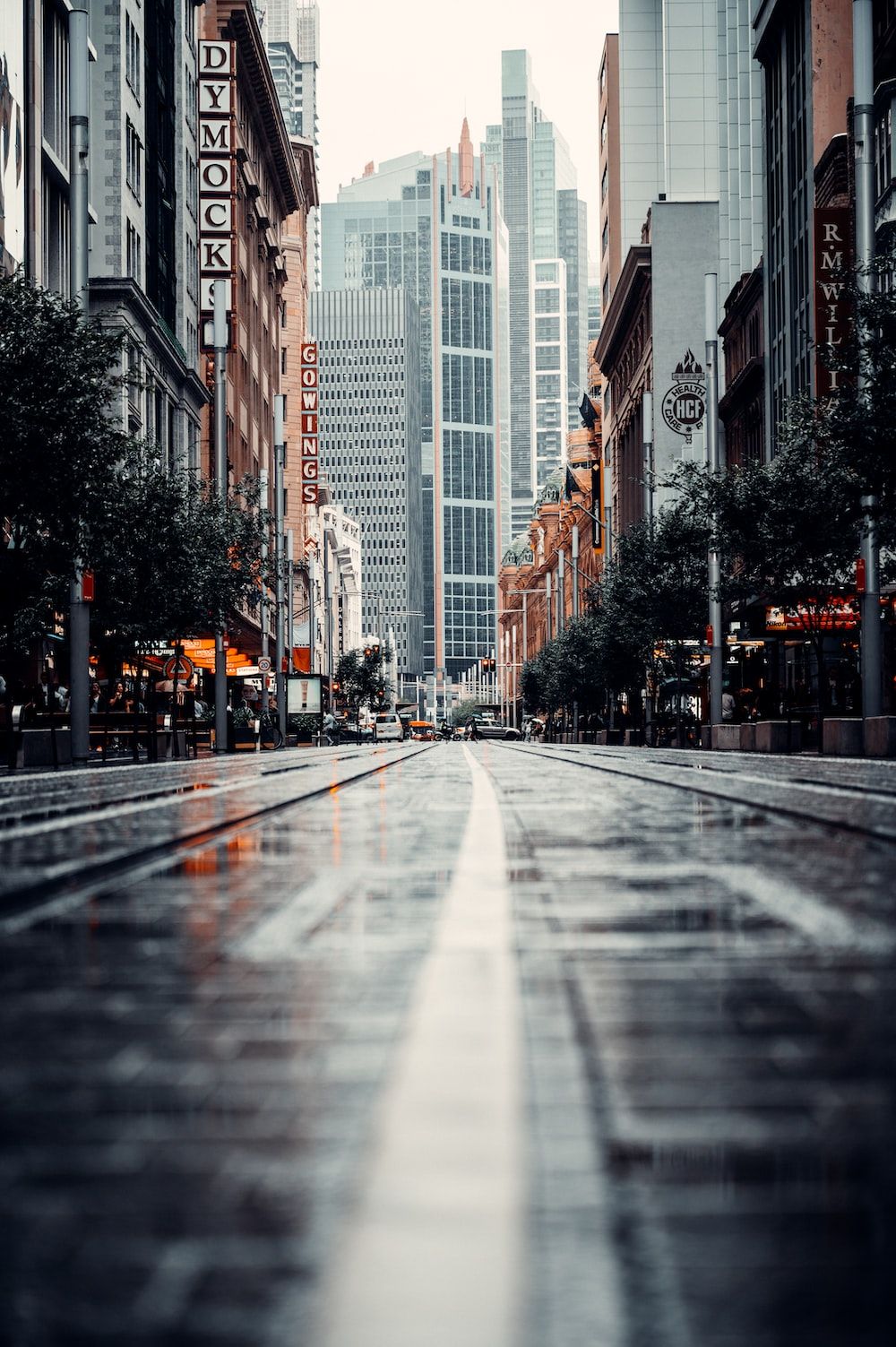 Gray concrete road between high rise buildings during daytime photo